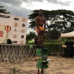 A man standing on crates of drinks performing a stunt at the asaba fun fair